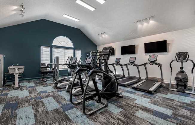 our fitness center has a lot of exercise equipment including cardio equipment and a window