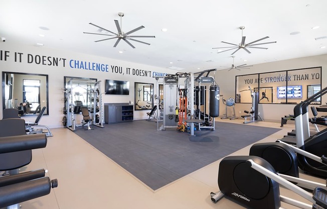 A gym with a variety of equipment and motivational quotes on the wall.
