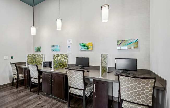 A room with a desk and chairs and a computer on it.