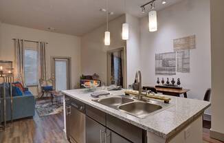 a kitchen with a sink and a view of a living room