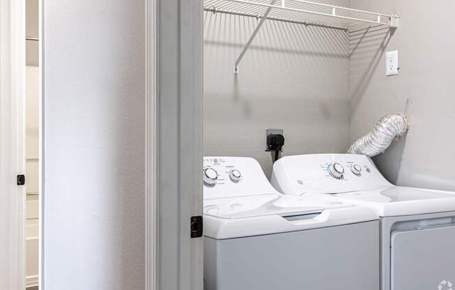 A white washing machine and dryer in a small laundry room.