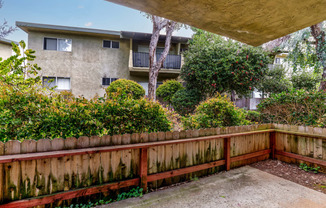 the backyard of an apartment building with a wooden fence