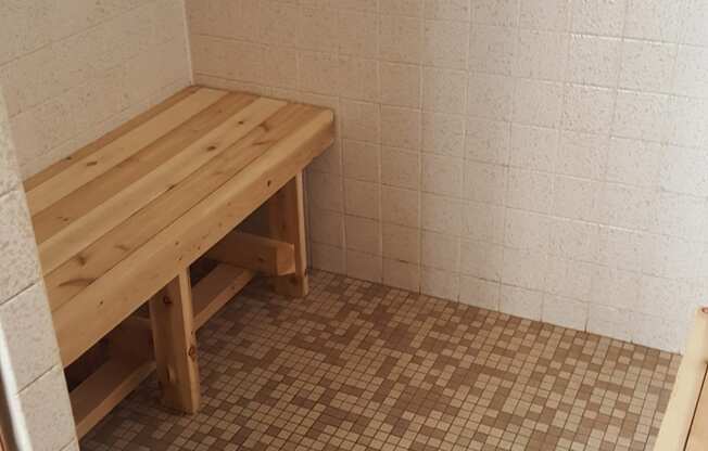 a small room with a wooden bench in a shower