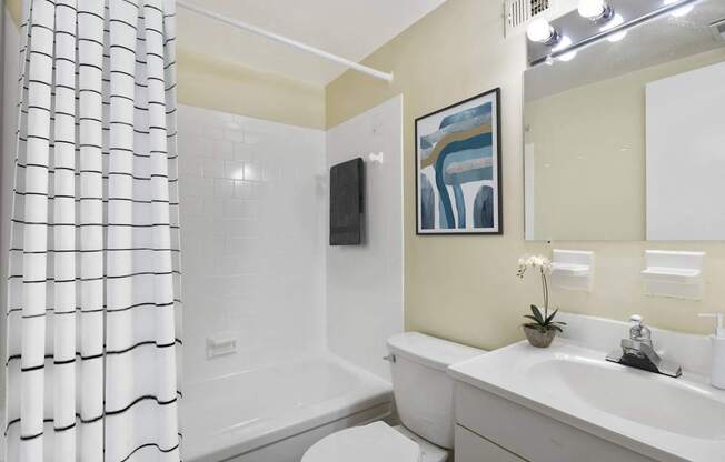 A bathroom with a white tub, sink, and toilet.