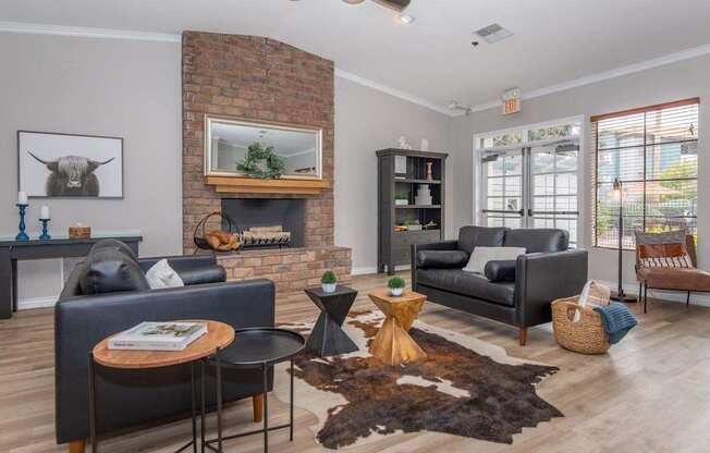 A living room with a fireplace and a cow picture on the wall.