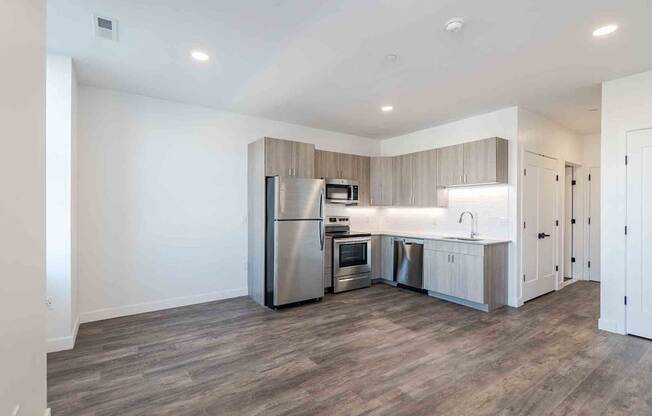 a kitchen with stainless steel appliances and wooden floors