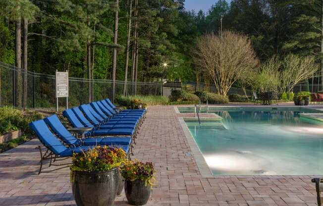 Veridian at Sandy Springs apartments resort pool with blue lounge chairs and potted plants