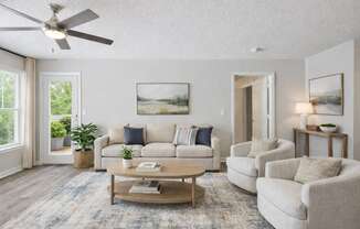 A living room with a couch, chairs, and a coffee table.