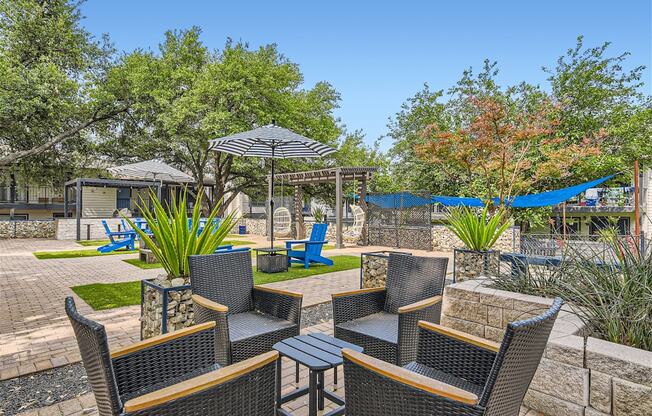 a patio with chairs and umbrellas and a hammock