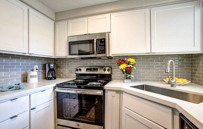 Apartments in Phoenix, AZ - Village at Lakewood Fully Equipped Kitchen with Stainless Steel Appliances and White Cabinetry