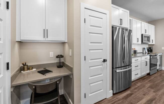 a kitchen with white cabinets and stainless steel appliances and a counter top with a refrigerator