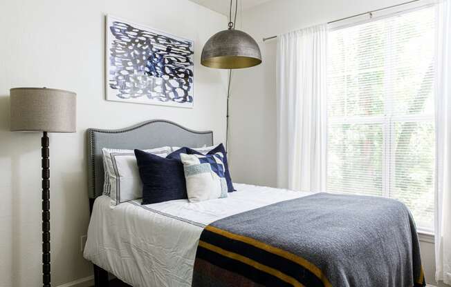 a bedroom with white walls and a bed with blue and white bedding
