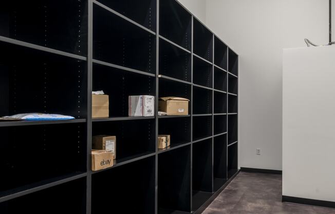 a room with black shelving with boxes on it and a white wall at The Draper, St Louis, MO