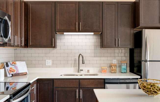 A kitchen with brown cabinets and a white countertop.