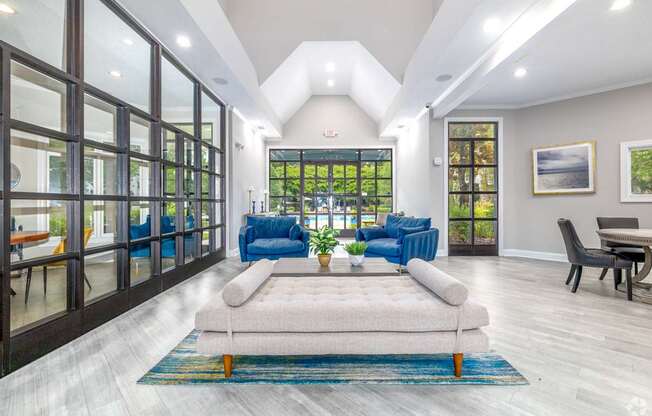 A modern living room with a large window and a view of the trees outside.