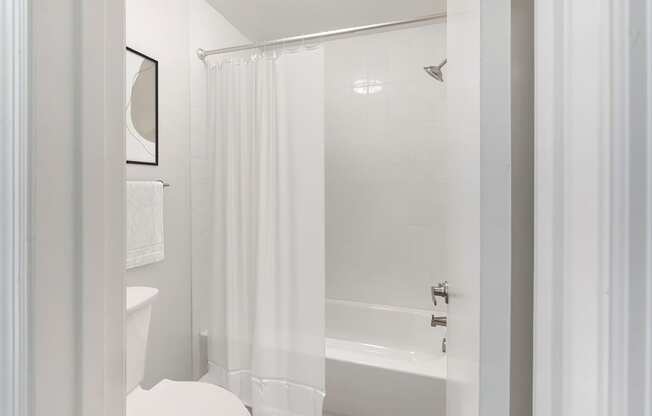 a white bathroom with a shower and a toilet