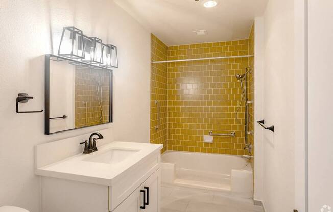 A bathroom with a yellow tiled shower area.