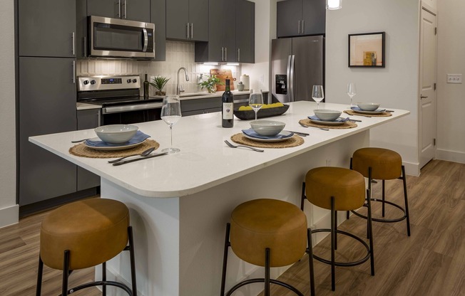 Indulge in culinary delights within Modera Garden Oaks' gourmet kitchens, highlighted by quartz countertops and custom 42-inch cabinetry featuring under-cabinet lighting for both style and practicality.