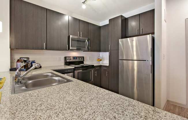 Apartments for Rent in San Marcos, TX - Radiate Kitchen with stainless steel appliances, and modern wood cabinets