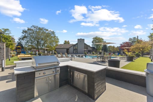 a patio with an outdoor kitchen and a swimming pool