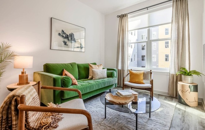 Model living room with a green couch and a window