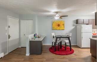 a kitchen and dining area with a small table and a refrigerator