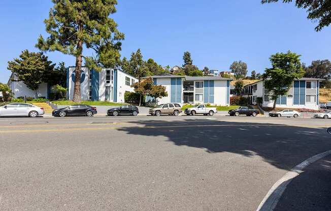 A parking lot with cars and a building in the background.