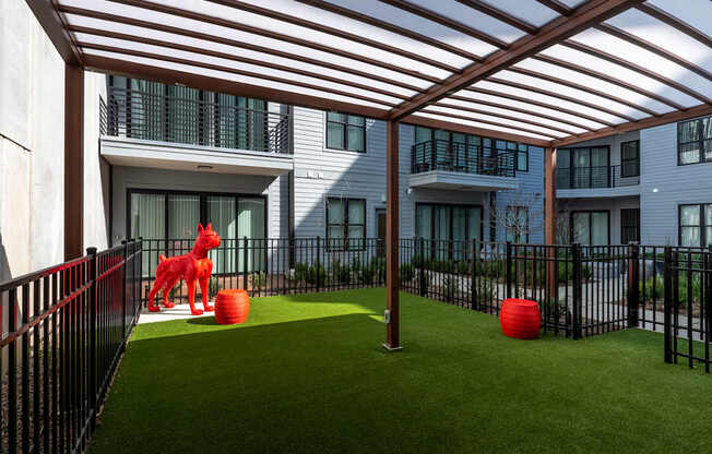 A dog statue is sitting on a green lawn.