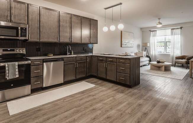 A modern kitchen with dark wood cabinets and stainless steel appliances.