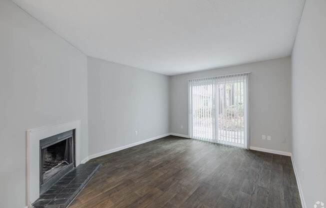 A room with a fireplace and wooden floors.