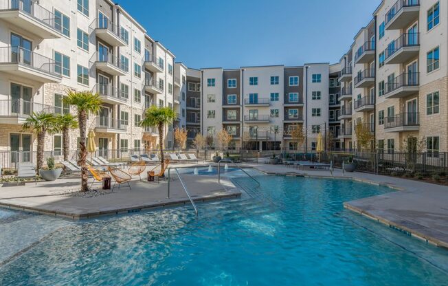 A swimming pool in front of apartment buildings.
