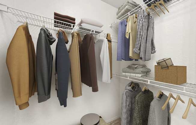 a walk in closet with a white closet organizer and a white rod with clothes hanging on it