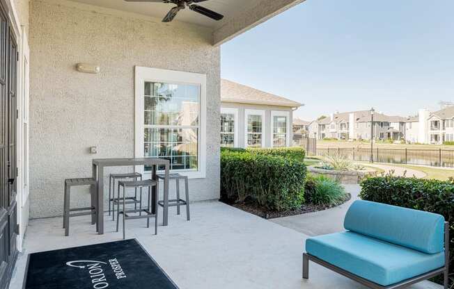 a patio with a table and chairs in front of a house