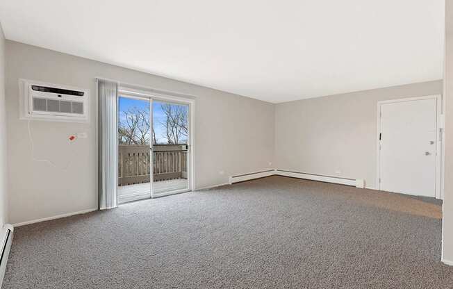 an empty living room with a door to a balcony