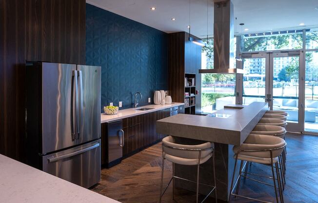 a kitchen with stainless steel appliances and a counter with bar stools at Sinclaire on Seminary, Alexandria, VA