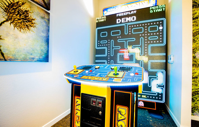 an arcade game in a room with a poster on the wall