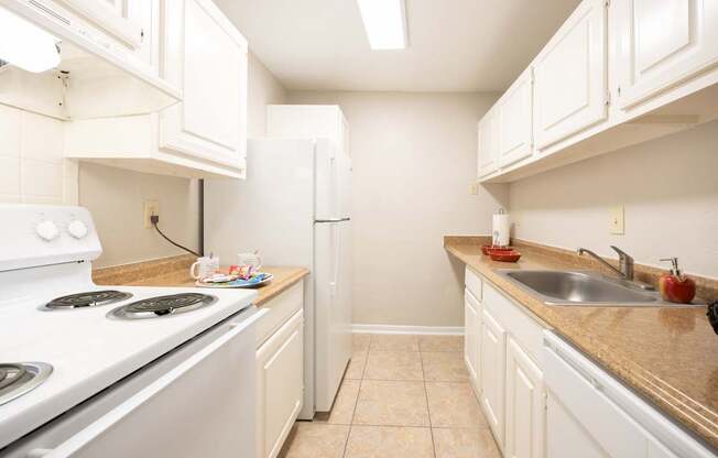 A kitchen with white appliances and cabinets.