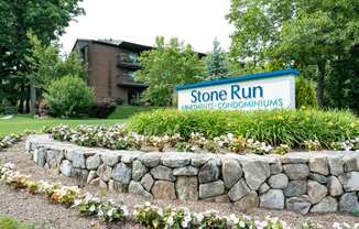 stone run entrance with flowers and plantings