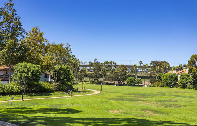 a large grassy field with trees and a blue sky at La Jolla Blue, California, 92122