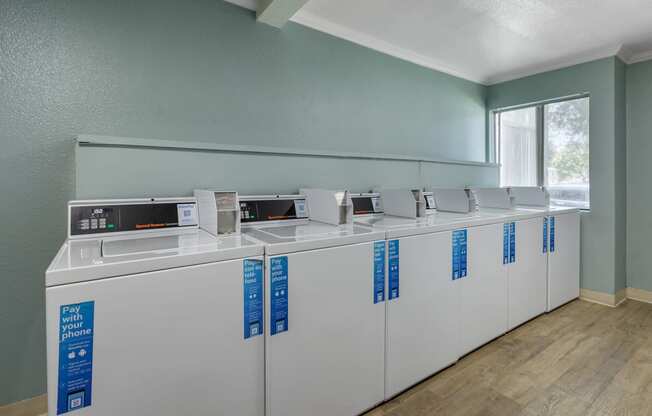a row of washers and dryers in a room