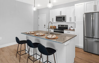 A kitchen with a bar area and a refrigerator.