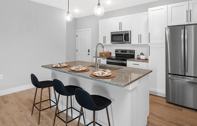 A kitchen with a bar area and a refrigerator.