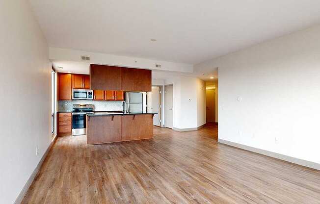 a kitchen and living room with wooden floors and white walls