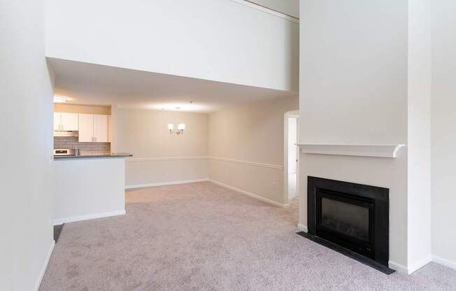 The Loft living room with a fireplace and grey carpet at Ledges Apartments in Weymouth.