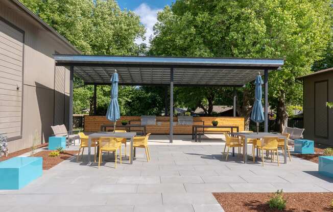 a patio with tables and chairs and awnings