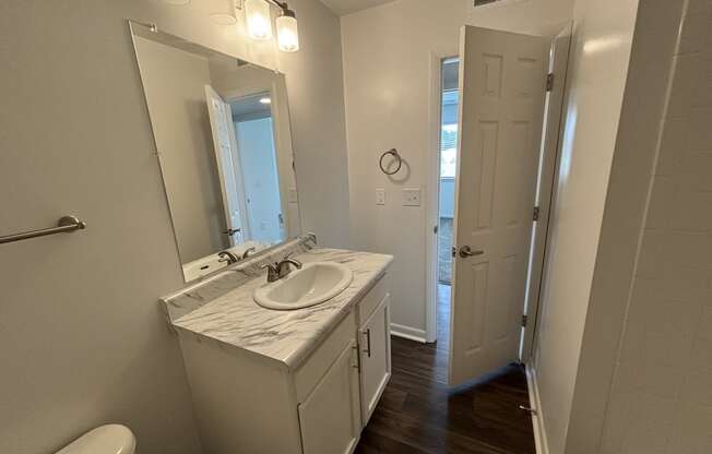 a bathroom with a sink and a mirror and a window