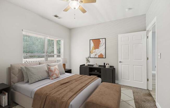 A bedroom with a bed, nightstand, and a ceiling fan.