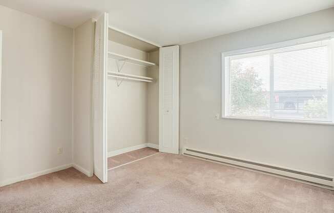 a bedroom with a large window and a closet