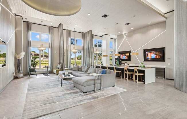 Clubhouse with a grey sofa set and a kitchen area at GreenVue apartments in Richardson, TX