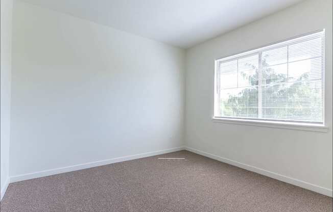 A room with a window and carpeted floor at Riverplace Apartment Homes, Independence, OR, 97351